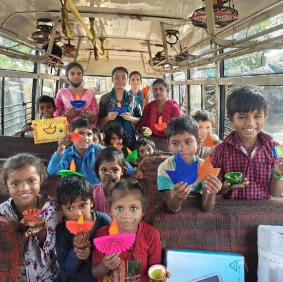 Children from Aasraa Trust’s Mobile Learning Centre in Dehradun take part in celebrations inside the educational bus, fostering cultural awareness and joy as part of the ASED-supported program.